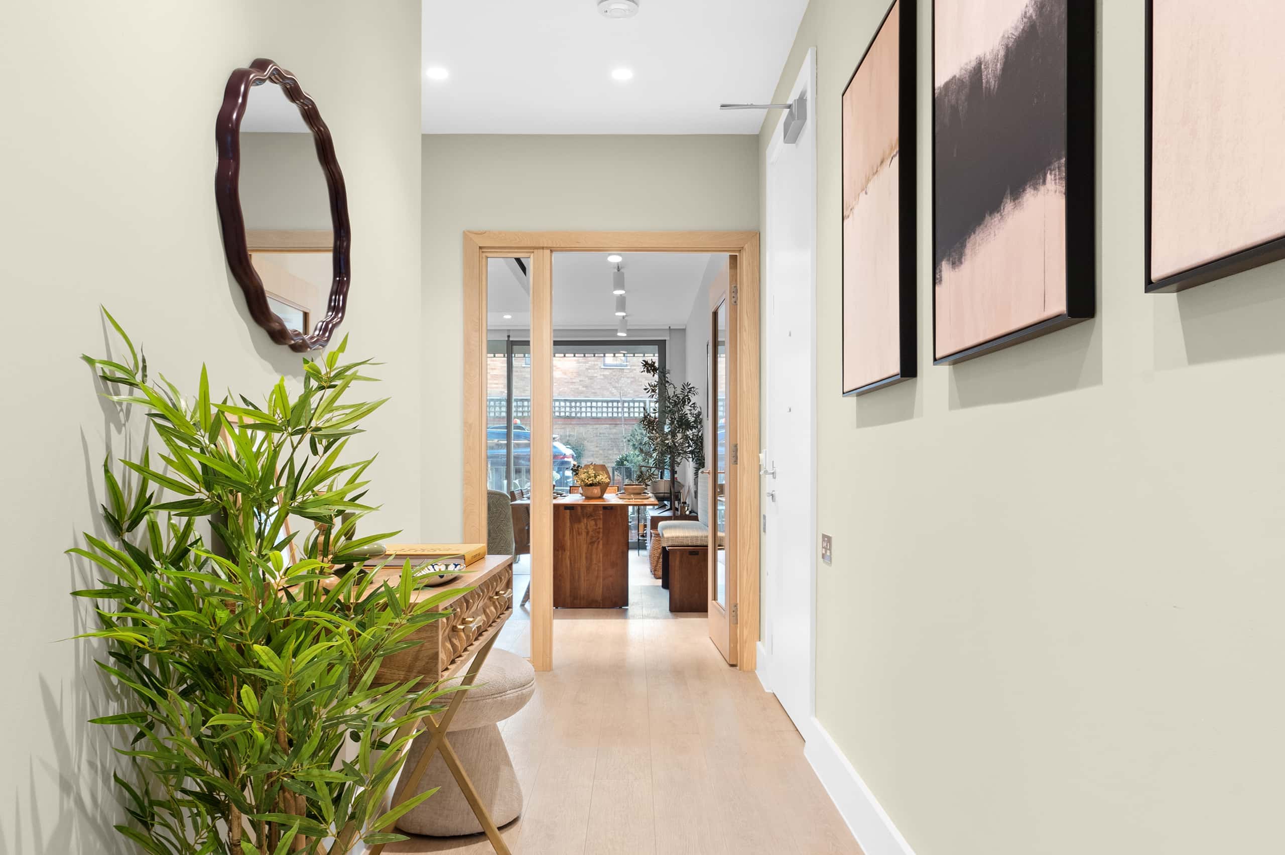 Bright and spacious hallway with wooden flooring and minimalist design, leading to open-plan living areas.