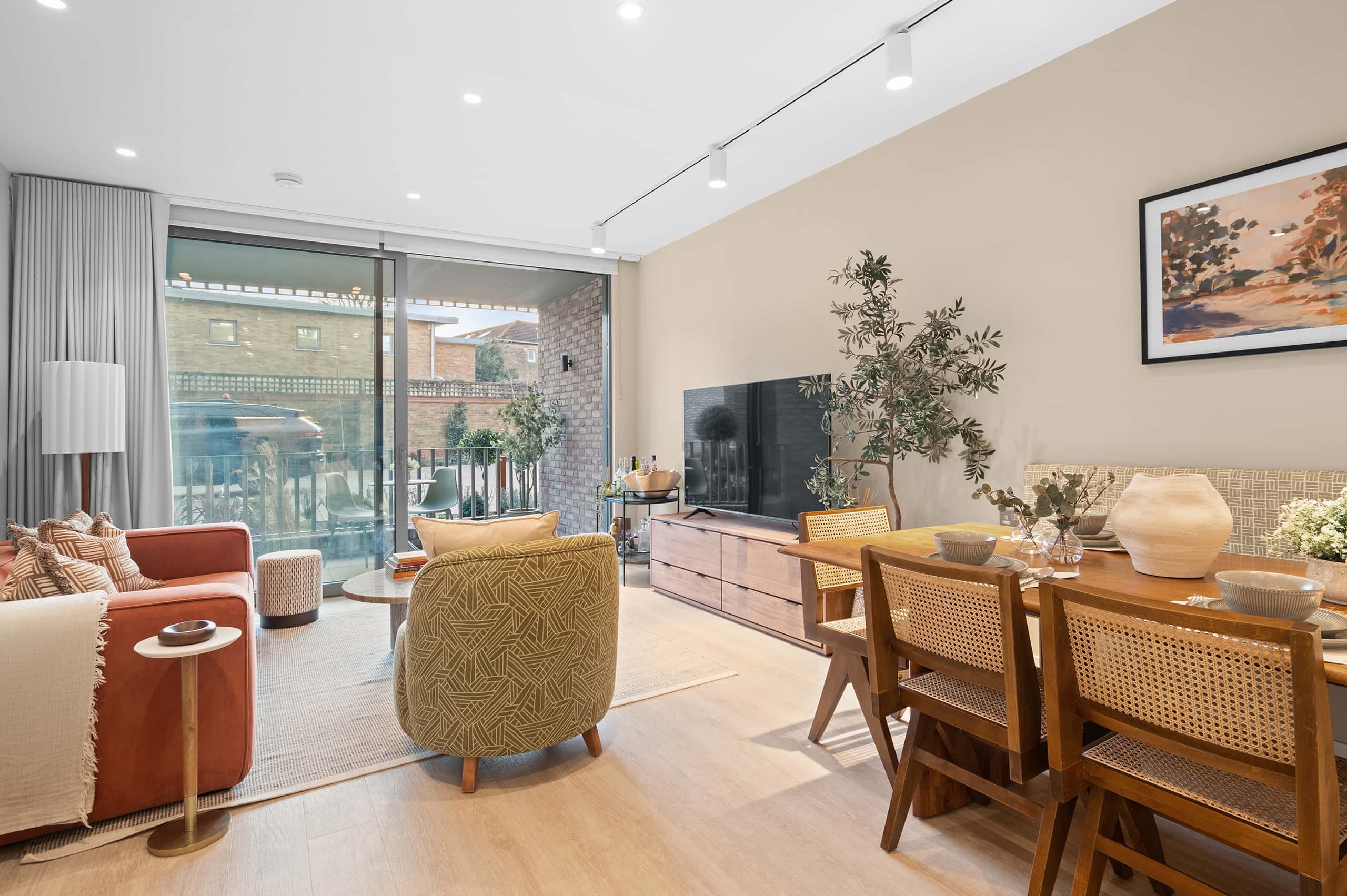 Stylish open-plan living room with floor-to-ceiling windows, modern furnishings, and access to a private outdoor space.