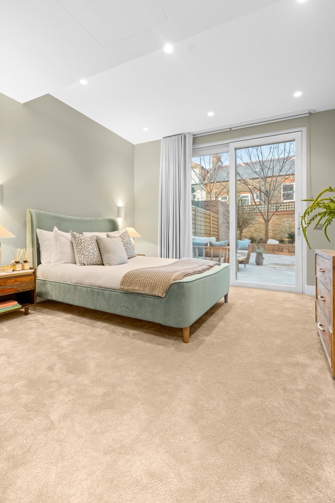 bedroom facing through large windows to ground floor garden
